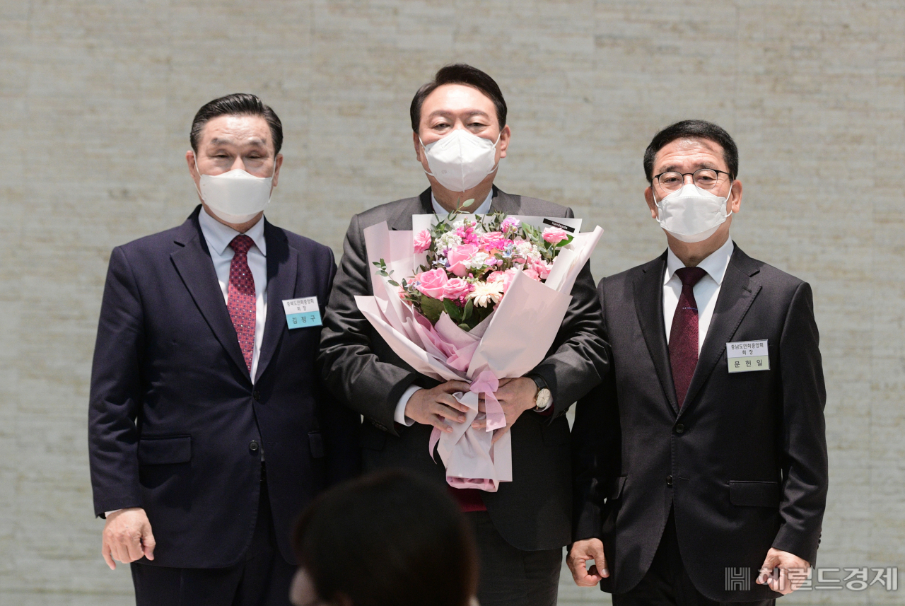 [헤럴드경제=이상섭 기자] 윤석열 국민의힘 대선 후보(가운데)가 8일 서울 영등포구 공군호텔에서 열린 충북 ‧ 충남도민회 주최 '국가균형발전 완성 결의대회'에 참석, 김정구 충북도민 회장(왼쪽)에게 꽃다발을 받은후 기념사진을 찍고 있다.