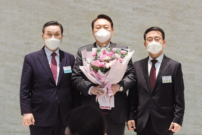 윤석열(가운데) 국민의힘 대선 후보가 8일 서울 영등포구 공군호텔에서 열린 충북·충남도민회 주최 ‘국가균형발전 완성 결의대회’에 참석, 김정구(왼쪽) 충북도민 회장에게 꽃다발을 받은후 기념사진을 찍고 있다. 이상섭 기자