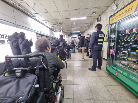 9일 전국장애인차별연대 회원들이 국가인권위원회에 진정서를 제출하기 위해 충무로역에 하차한 뒤 승강기에 탑승하기 위해 일렬로 줄을 서 대기하고 있다.