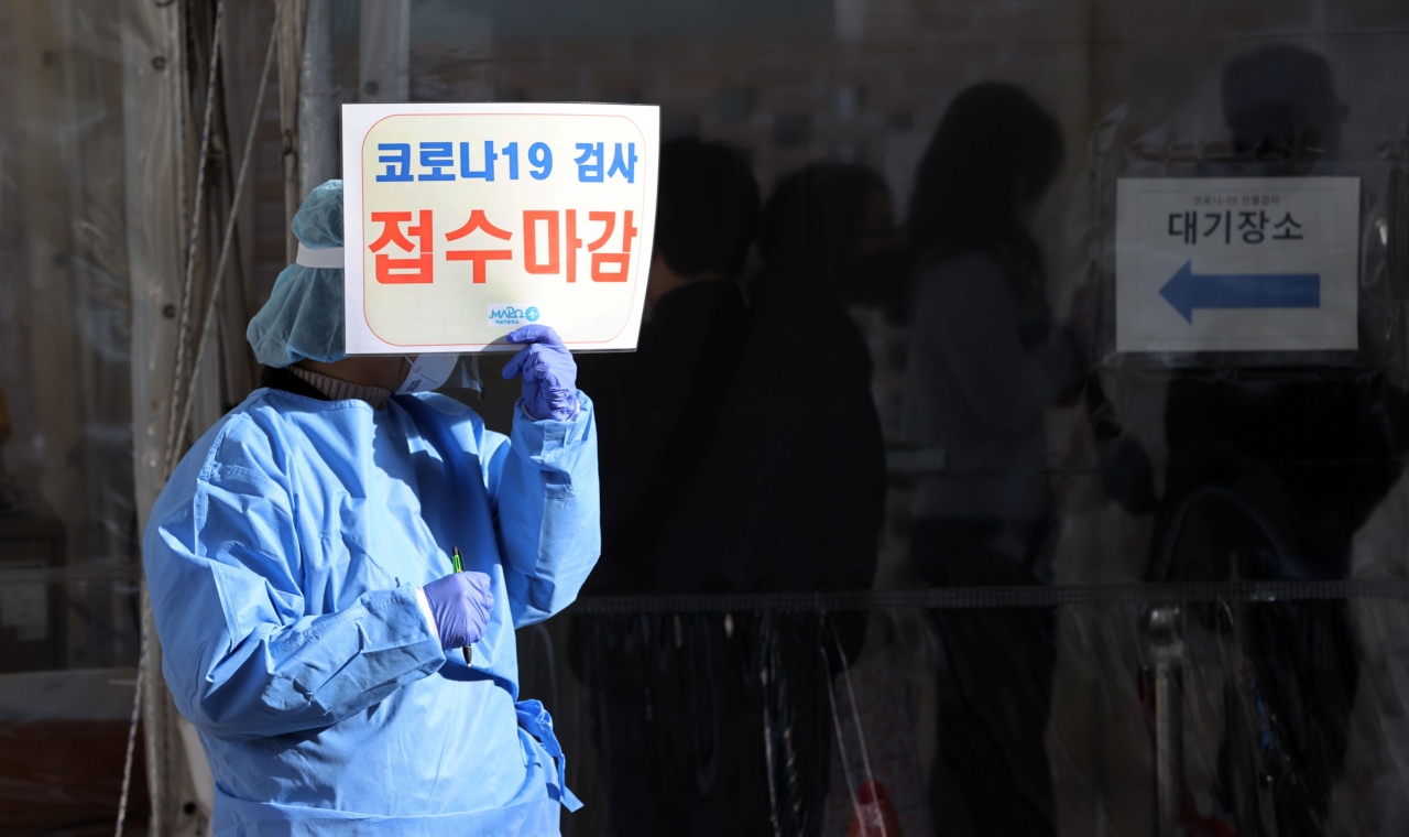 9일 오전 서울 마포구보건소 신종 코로나바이러스 감염증(코로나19) 선별진료소에서 의료진이 오전 검사 접수 마감 안내문을 들고 있다. [연합]