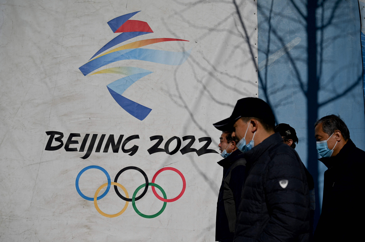 중국 베이징(北京市) 시민이 지난 1일 2022년 베이징 동계 올림픽이 열릴 예정인 서우강(首鋼) 공원 앞을 지나고 있다. [AFP]