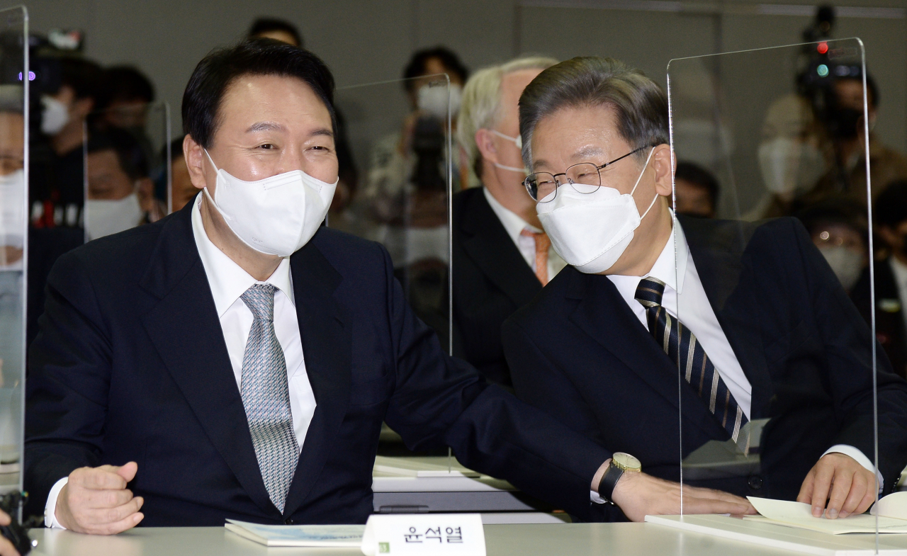 이재명 더불어민주당 대선후보(오른쪽)와 윤석열 국민의힘 대선후보가 9일 서울 마포구 연세대 김대중도서관에서 열린 '김대중 대통령 노벨평화상 수상 21주년 기념식 및 학술회의'에 참석해 대화하고 있다. [연합]