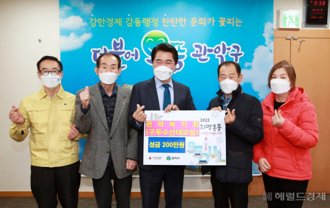 관악구 구두수선대 모임인 관악녹지회 회원들이 성금을 전달한 뒤 박준희 구청장과 기념사진을 찍고 있다.[관악구]