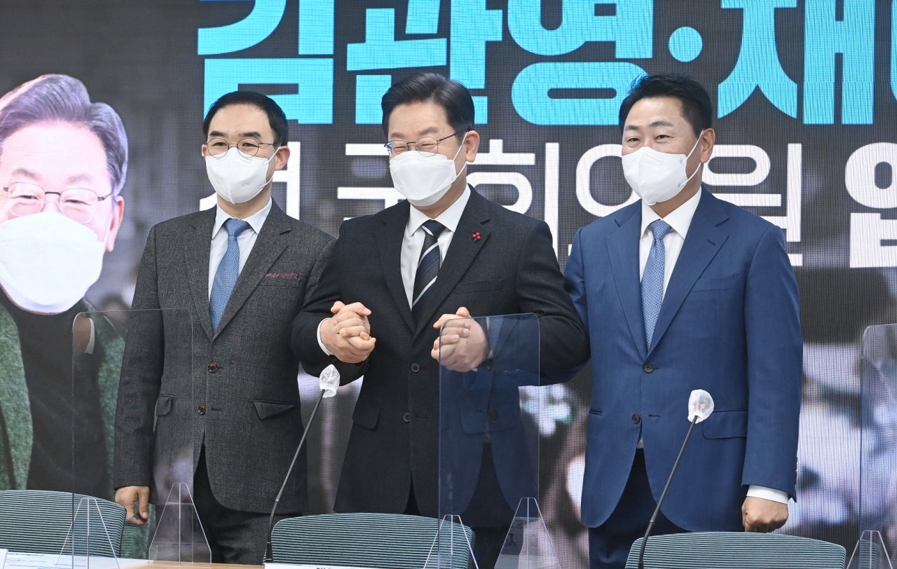 더불어민주당 이재명(가운데) 대선후보가 10일 오전 서울 영등포구 더불어민주당사에서 열린 바른미래당 출신 김관영(오른쪽), 채이배 전 의원의 입당식에서 두 전 의원의 손을 잡고 있다. [연합]