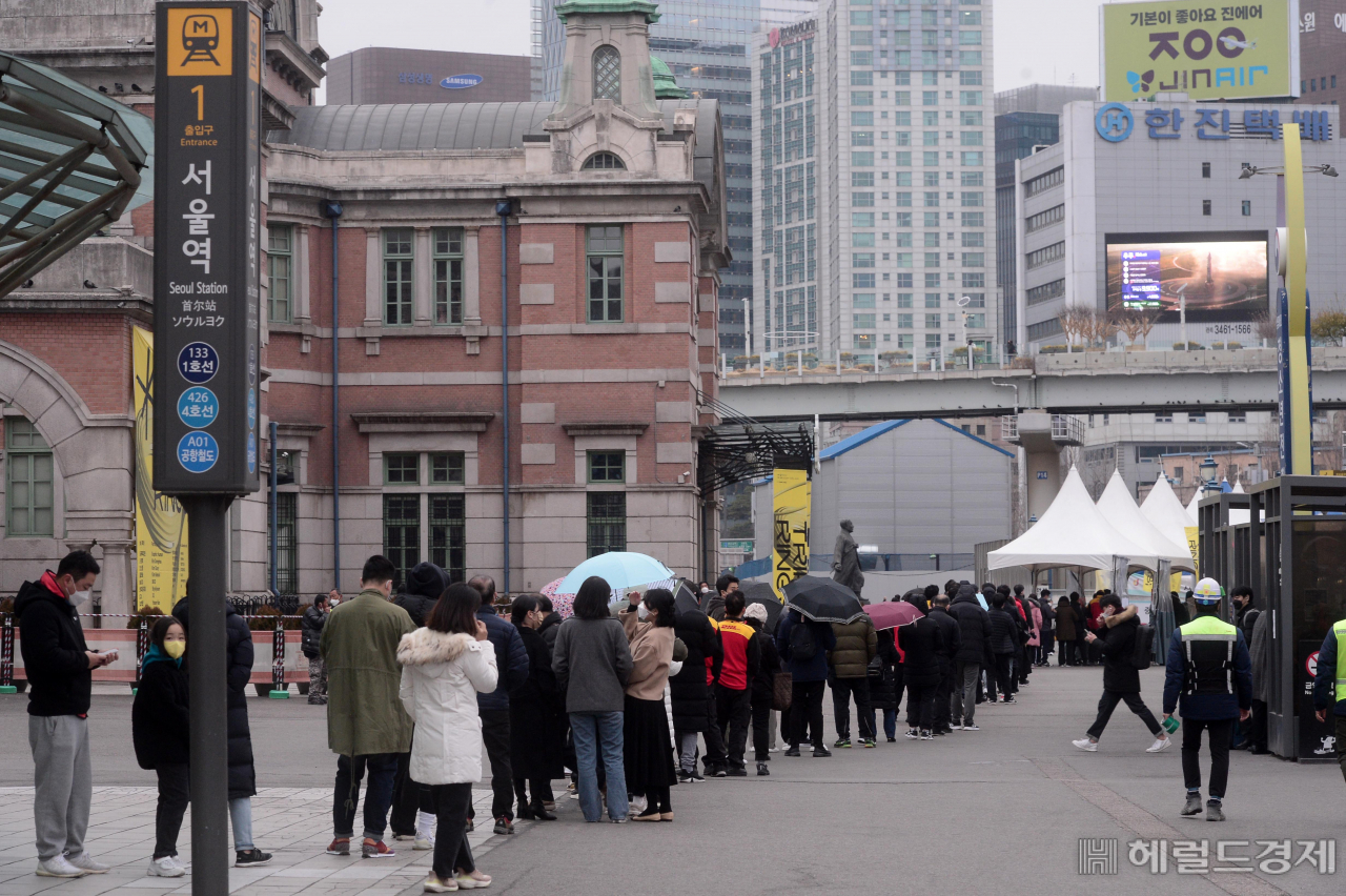 10일 오전 서울 중구 서울역 코로나19 임시선별검사소를 찾은 시민들이 우산을 쓰고 검사 차례를 기다리고 있다. [박해묵 기자]