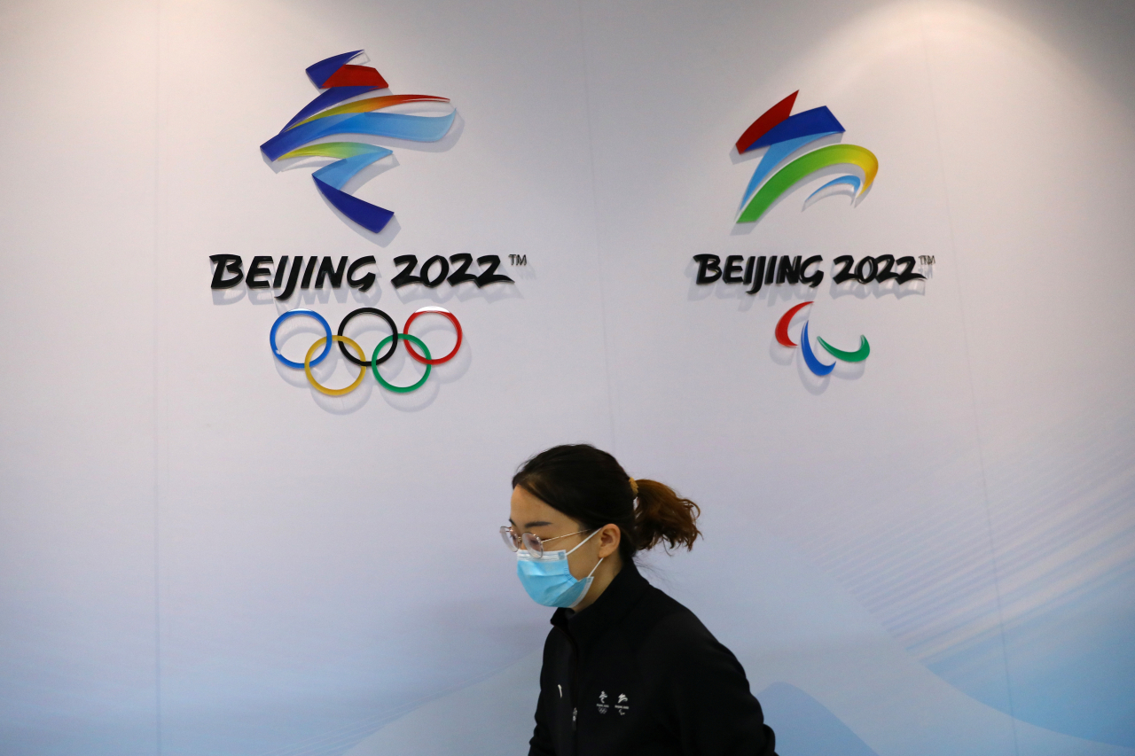 중국 베이징(北京市) 시민이 9일 2022년 베이징 동계 올림픽 로고 앞을 지나고 있다. [로이터]