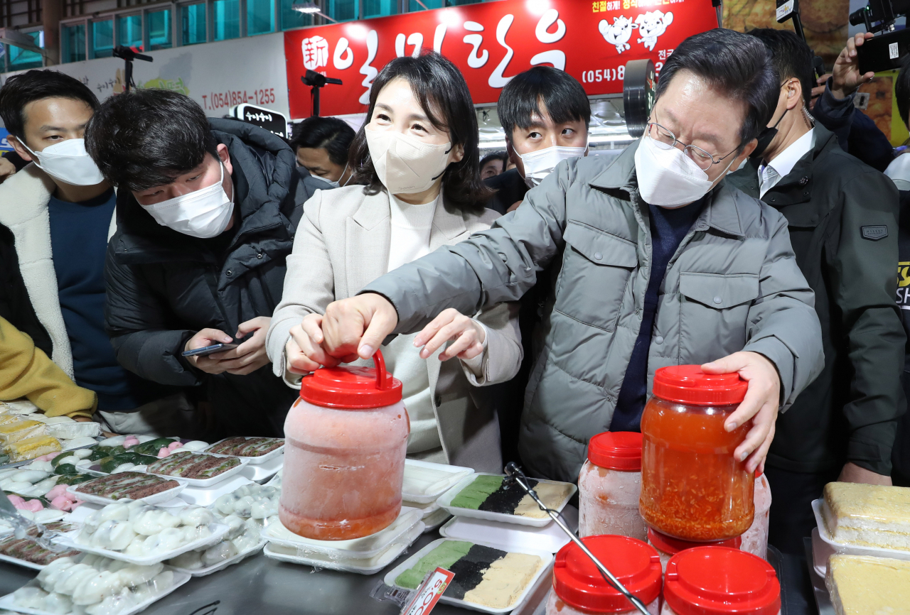 고향인 안동을 방문한 이재명 더불어민주당 대선 후보와 배우자 김혜경 씨가 11일 경북 안동시 안동 중앙신시장을 찾아 안동식혜를 구입하고 있다. [연합]