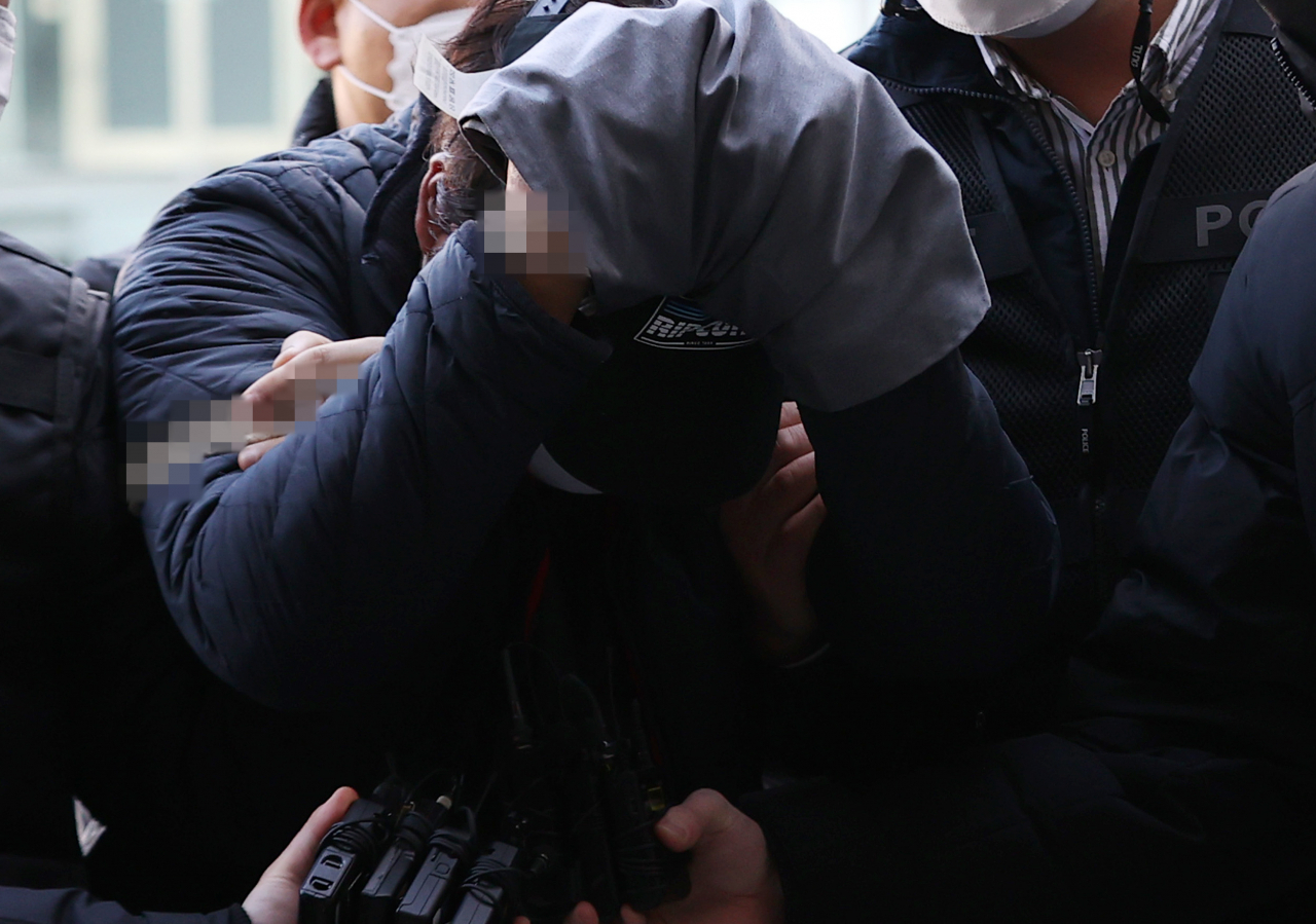 교제했던 여성의 집을 찾아가 가족을 살해한 이모씨가 12일 오후 서울 송파구 서울동부지법에서 열린 영장실질심사에 출석하기 위해 법정으로 향하고 있다. 연합뉴스