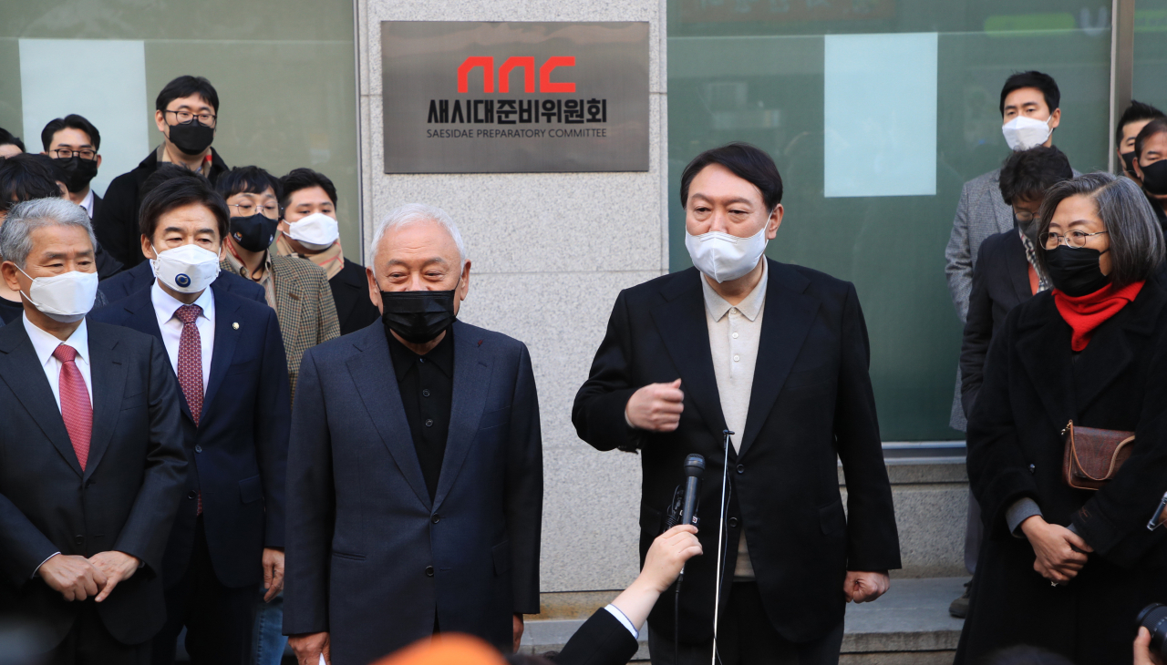 윤석열 국민의힘 대선후보가 12일 오후 영등포구 여의도 새시대준비위원회 사무실 앞에서 참석자들과 함께 현판 제막식을 마친 뒤 취재진의 질문에 답변하고 있다. [연합]