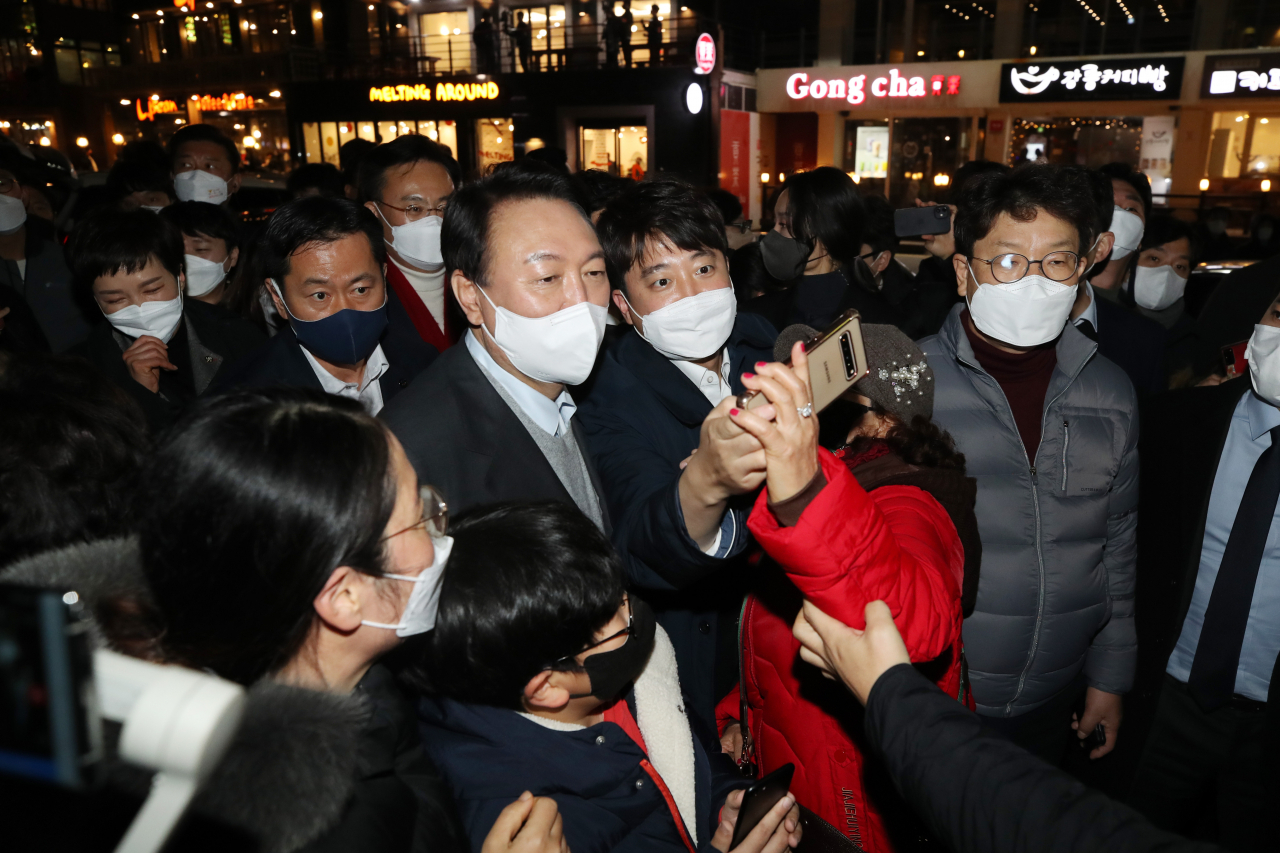 윤석열 국민의힘 대선후보와 이준석 대표가 10일 저녁 강원 강릉시 커피거리를 방문해 시민들과 인사하며 사진을 찍고 있다. [연합]