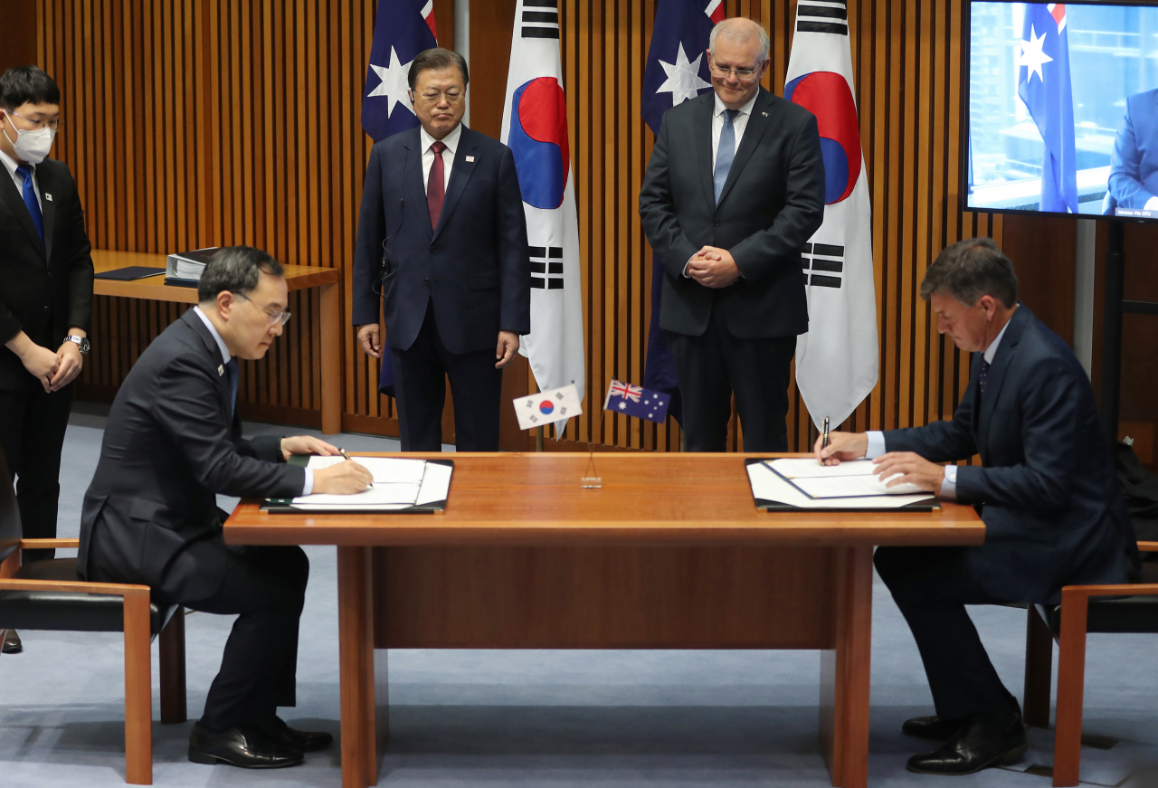 호주를 국빈 방문 중인 문재인 대통령과 스콧 모리슨 호주 총리가 13일 캔버라 국회의사당 대위원회실에서 열린 정상회담을 마친 뒤 문승욱 산업통상자원부 장관과 앵거스 테일러 호주 산업·에너지·배출저감부 장관의 '한-호주 탄소중립기술 파트너십 이행계획 MOU' 체결을 지켜보고 있다. 연합뉴스