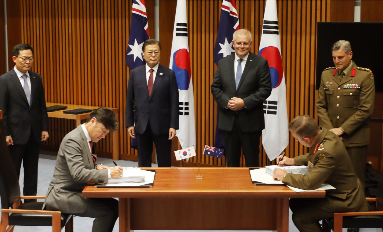 호주를 국빈 방문 중인 문재인 대통령이 스콧 모리슨 총리와 13일 캔버라 국회의사당에서 한화 디펜스와 호주 국방부획득관리단의 호주 육군 K-9 자주포 획득사업 계약 서명을 지켜보고 있다. 연합뉴스