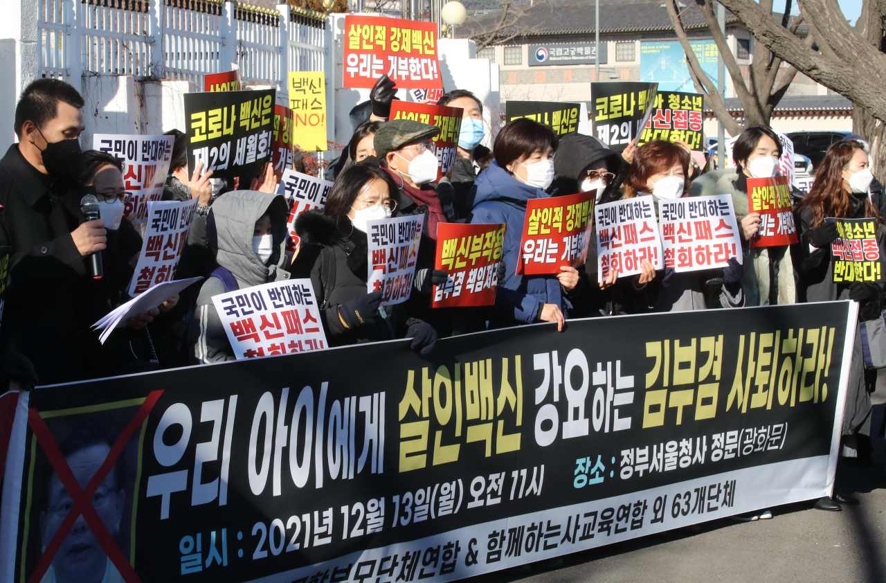 13일 정부서울청사 앞에서 열린 방역패스 및 청소년 백신접종 반대 기자회견에서 전국학부모단체연합 등 시민단체 및 학부모들이 손팻말을 들고 있다. [연합]