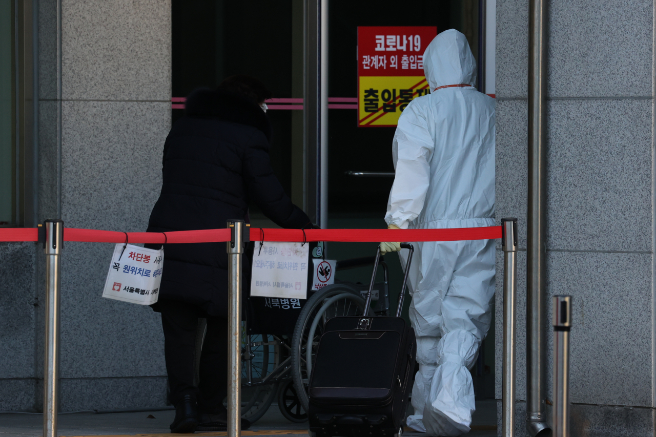 13일 오후 서울 은평구 서울특별시립 서북병원에서 한 코로나19 환자가 의료진의 도움을 받아 입원하고 있다. [연합]