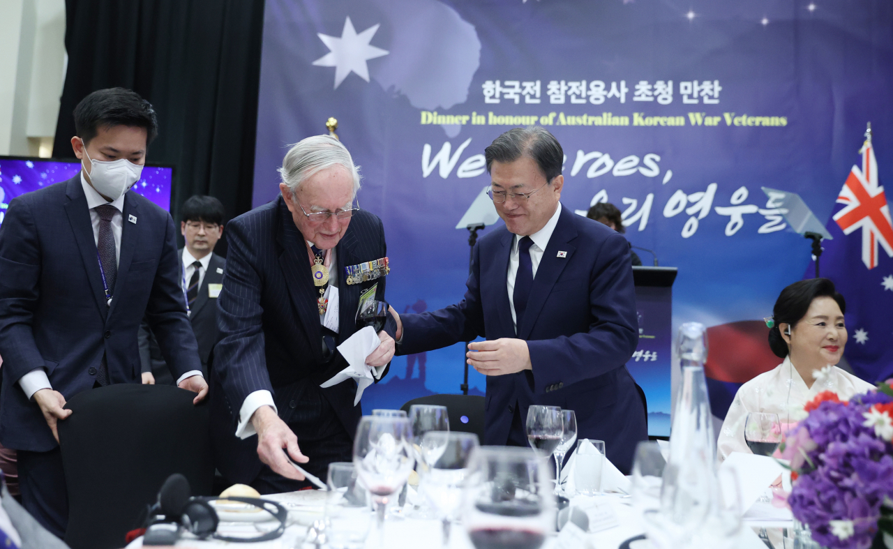 호주를 국빈 방문 중인 문재인 대통령이 13일 캔버라 시내 한 호텔에서 열린 한국전 참전용사 초청 만찬에서 건배사를 마친 참전용사 이안 크로포드 제독을 부축해 자리에 앉고 있다. 연합뉴스