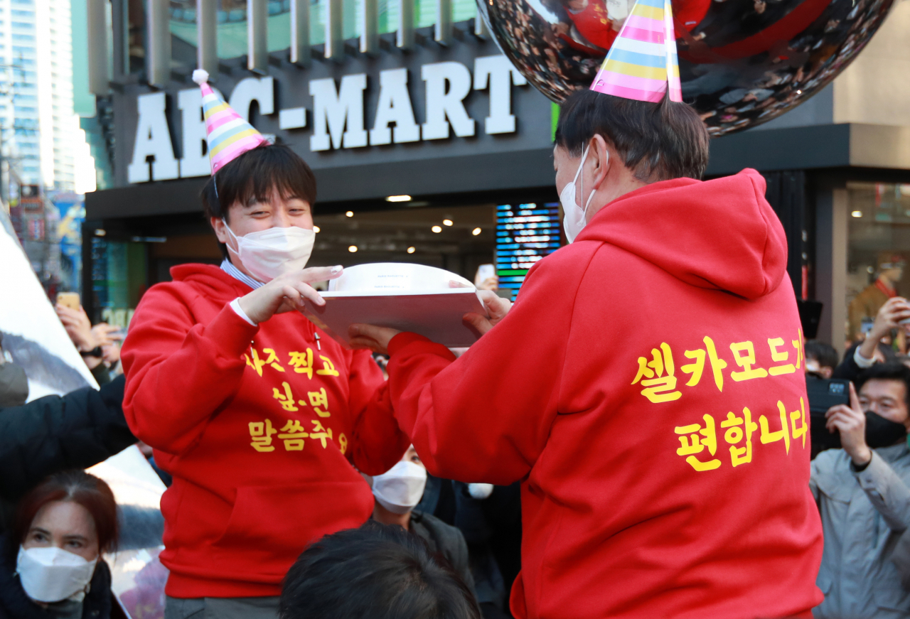4일 부산 서면 시내 거리에서 윤석열 대선 후보와 이준석 대표가 앞 뒷면에 노란색 글씨로 '사진 찍고 싶으면 말씀 주세요', '셀카 모드가 편합니다'라고 적힌 빨간색 후드티를 입고 유세를 하는 모습. [연합]