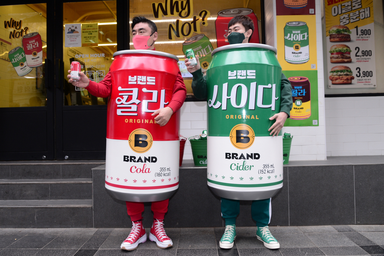 송현석 신세계푸드 대표이사(왼쪽)와 이대희 수원호매실점 가맹점주가 14일 오전 서울 중구 노브랜드 버거 서울시청점 앞에서 특별 제작한 콜라맨, 사이다맨 의상을 입고 포즈를 취하고 있다. [박해묵 기자]