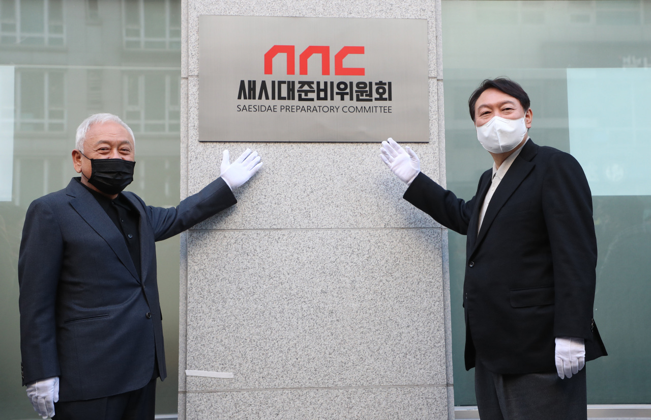 Yoon Suk-yeol (right), presidential nominee of the main opposition People Power Party, poses for a photo Sunday with former Democratic Party leader Kim Han-gil in celebrating the opening of the Sasidae Preparatory Committee. (Joint Press Corps)