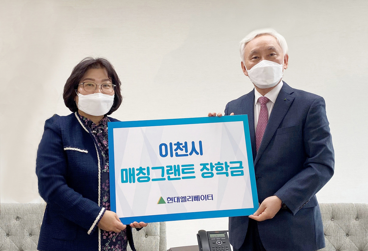 현대엘리베이터 송승봉 대표이사(오른쪽)가 14일 채점숙 이천시자원봉사센터 사무국장(왼쪽)에게 장학증서를 전달하고 있다. [현대엘리베이터 제공]