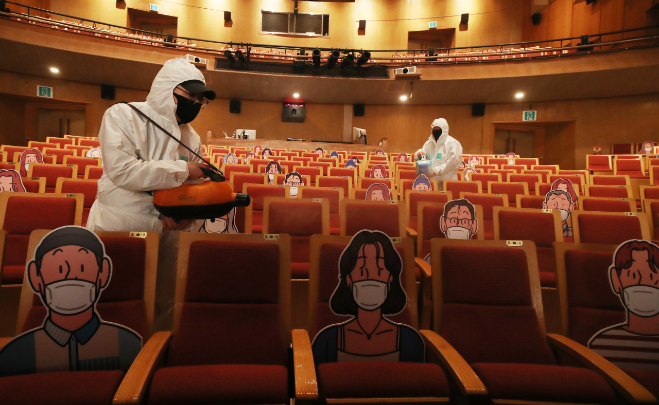 15일 오후 경기도 수원시 경기아트센터에서 관계자들이 신종 코로나바이러스 감염증(코로나19) 예방을 위한 거리두기 객석 사이를 소독하고 있다. [연합]