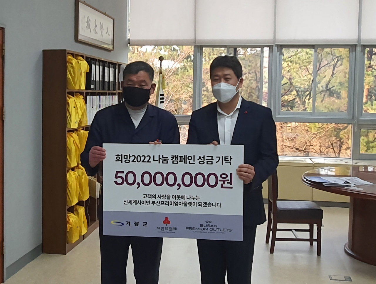 신세계사이먼 기장군 기탁식에서 왼쪽부터 오규석 기장군수 김희석 신세계사이먼 부산 프리미엄 아울렛 점장이 기념 촬영을 하고 있다. [신세계사이먼 제공]