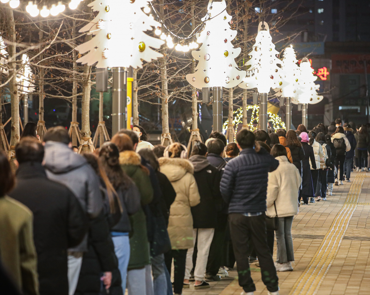 코로나19 신규 확진이 연일 7000명대를 기록하는 등 방역 한계 상황에 다다르자 정부가 다시 사회적 거리두기 단계 강화를 발표한 16일 오후 서울 서대문구 신촌역 광장에 마련된 선별진료소를 찾은 시민들이 성탄과 연말을 상징하는 트리 조명 아래 코로나19 검사를 받기 위해 줄지어 서 있다. [연합]