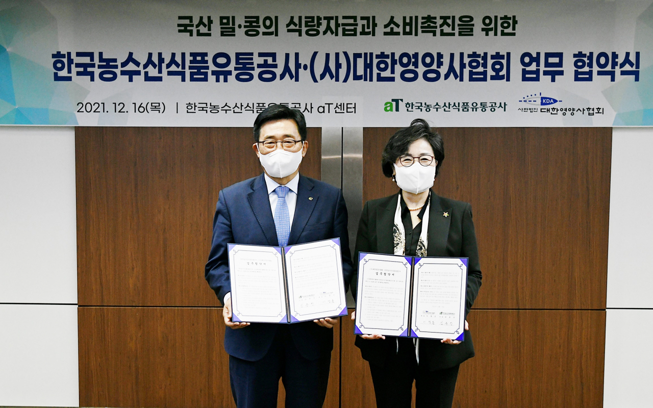 김춘진(왼쪽) 한국농수산식품유통공사사장이 16일 서울 양재동 aT센터에서 (사)대한영양사협회과국산 밀·콩의 식량자급과 소비촉진을 위한 업무협약을 체결한 후 기념촬영을 하고 있다.[한국농수산식품유통공사 제공]