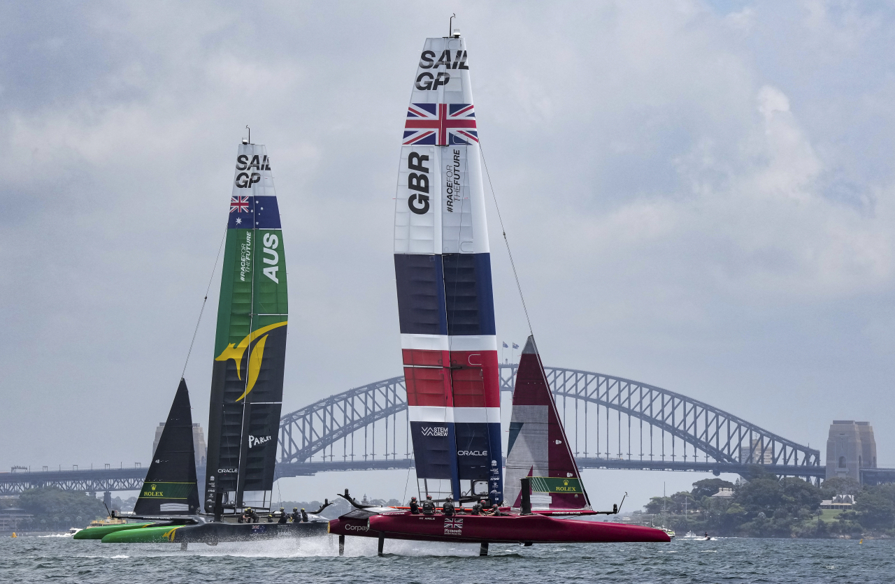 16일(현지시간) 호주 시드니 하버 브릿지 앞으로 세일그랑프리(Australia Sail Grand Prix) 대회에 참여한 대영제국의 국기를 단 보트가 보인다. [AP 연합]