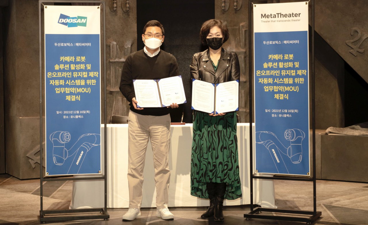 류경훈(왼쪽) 두산로보틱스 대표와 신정화 메타씨어터 대표가 ‘카메라로봇 솔루션 활성화 및 온오프라인 뮤지컬 제작 자동화 시스템’을 위한 업무 협약을 체결하고 기념사진을 촬영하고 있다. [두산 제공]