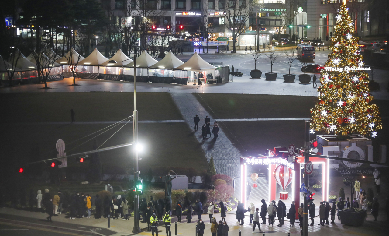 지난 17일 오후 전국적으로 기온이 떨어진 가운데 서울시청 앞 서울광장 선별진료소에서 퇴근길 시민들이 검사를 위해 대기해 있다. [연합]
