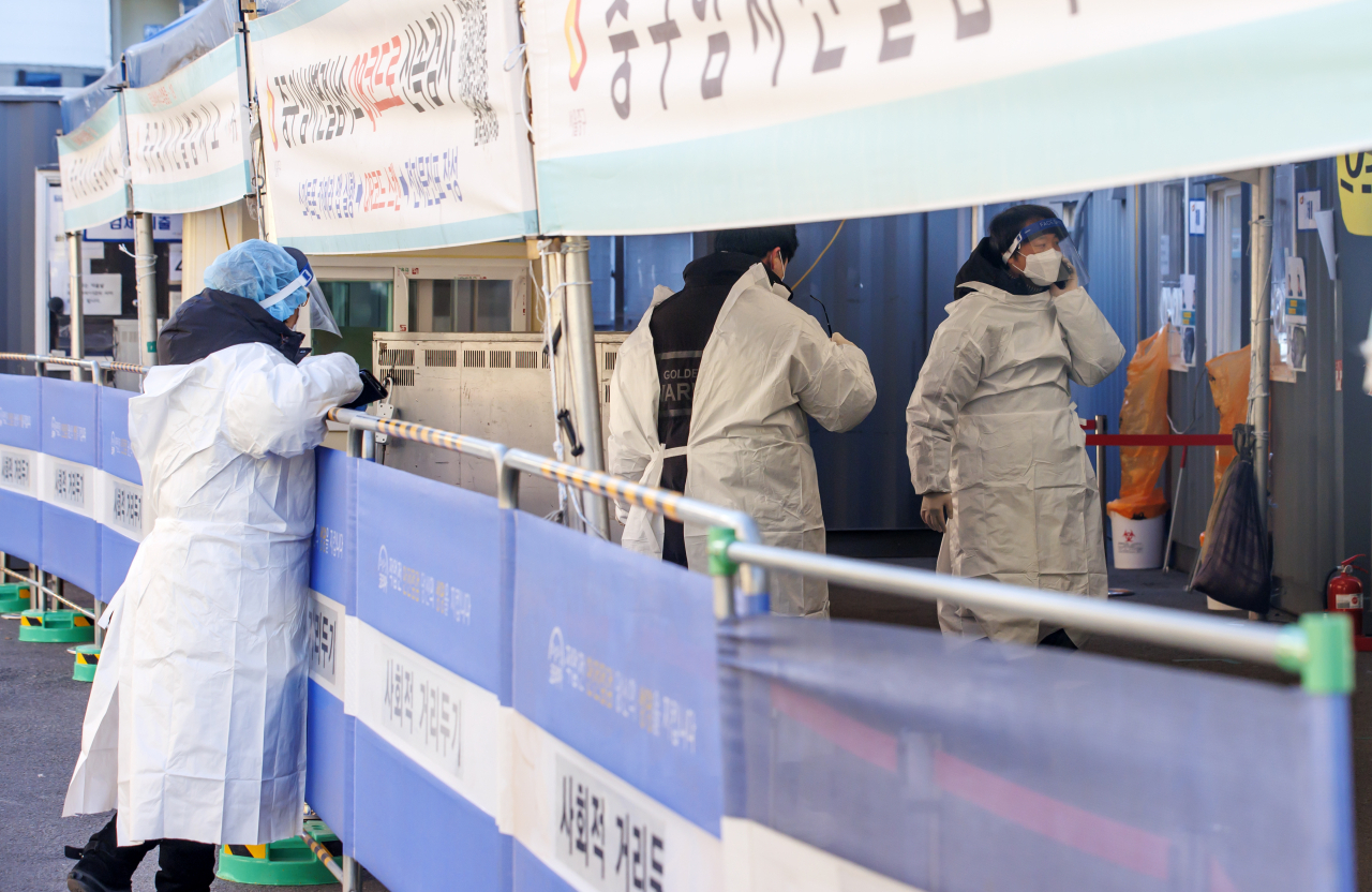 질병관리청에서 관리하는 코로나19 선별검사 시스템 접속에 문제가 생긴 18일 서울역 광장에 마련된 임시 선별검사소에서 관계자들이 문제 확인을 위해 분주하게 움직이고 있다. [연합]