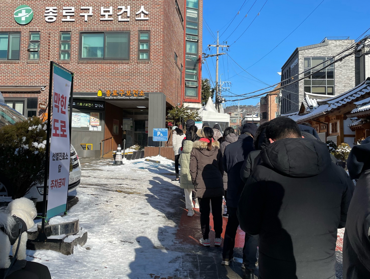 19일 오전 코로나19 선별진료소가 마련된 서울 종로구 보건소 앞에서 시민들이 줄을 서 있다.단계적 일상회복이 중단되고 다시 '사회적 거리두기' 조치가 시행된 둘째 날인 이날 국내 코로나19 신규 확진자 수는 6000명대 초반을 기록했다. [연합뉴스]