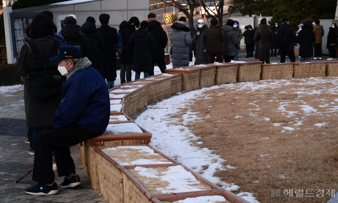 중앙방역대책본부가 20일 0시 기준 코로나19 신규 확진자가 5318명이라고 밝혔다. 이 날 오전 서울 용산구 보건소에 마련된 선별진료소를 찾은 한 노인이 줄 끝에 앉아 차례를 기다리고 있다. 박해묵 기자