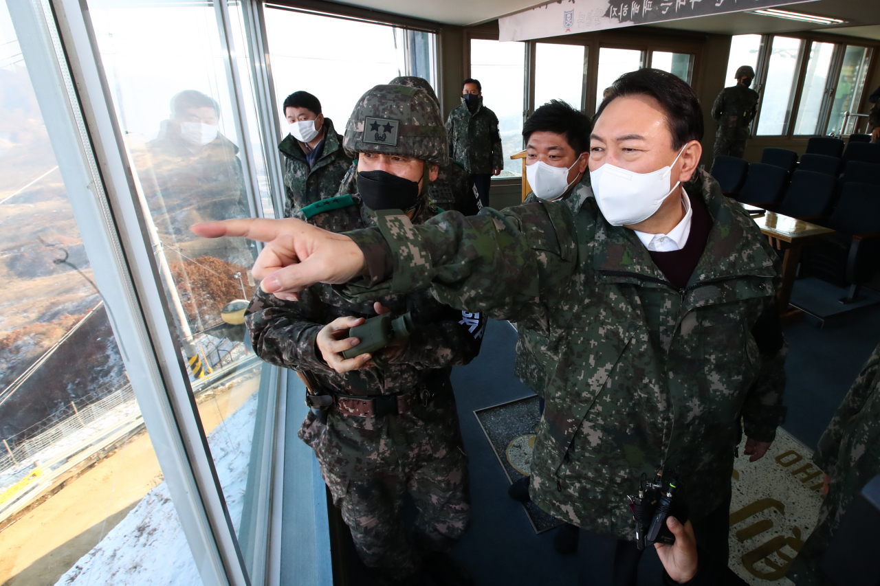 윤석열 국민의힘 대선 후보가 20일 강원도 철원 육군 3사단 부대(백골 OP)를 방문해 군관계자에게 보고를 받은뒤 손식 육군 3사단장(왼쪽)과 북측을 바라보고 있다. [연합]
