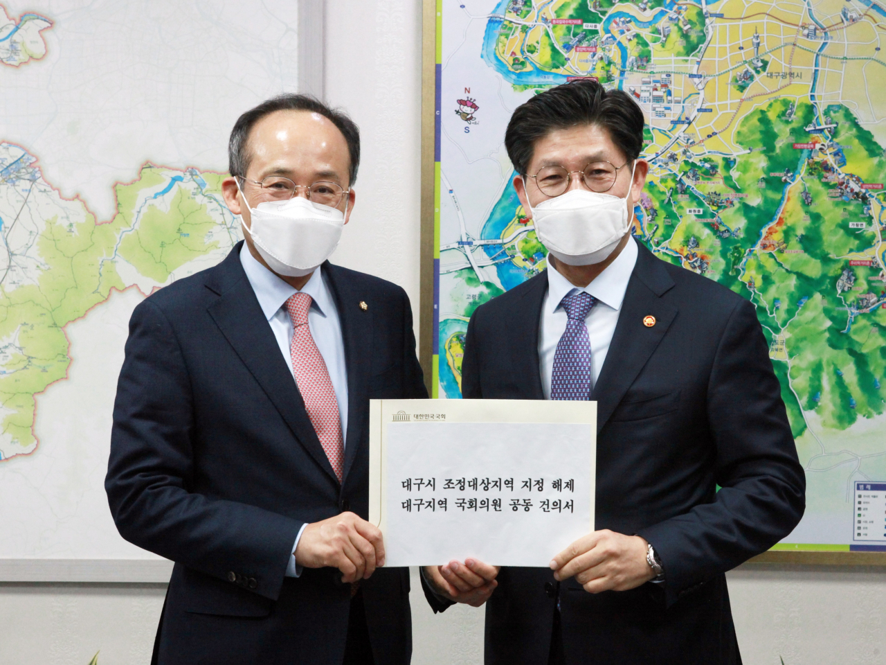추경호 국민의힘 대구시당 위원장(왼쪽)이 노형욱 국토교통부 장관에게 조정지역 해제 건의문을 전달하고 있다.[국민의힘 대구시당 제공]