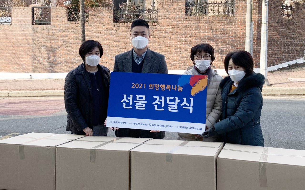 골프존문화재단이 충북 지역 아동센터 관계자들에게 아동용 선물 키트를 전달하고 있다.