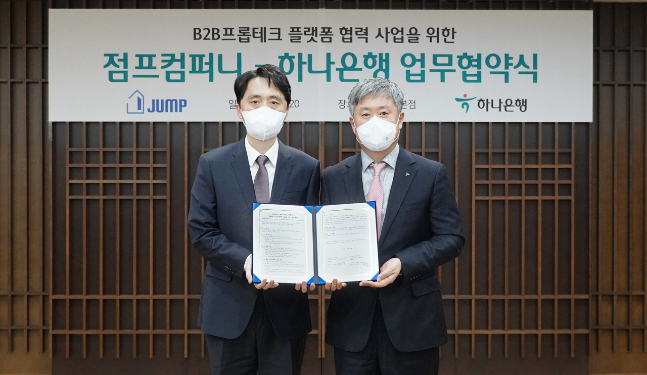 하나은행은 지난 20일 오후 을지로 본점에서 프롭테크 전문기업 점프컴퍼니와 '프롭테크 플랫폼 협력 사업'을 위한 업무협약을 체결했다. 이날 협약식에 참석한 이동현 하나은행 기업사업본부장(사진 오른쪽)은 박희영 점프컴퍼니 대표이사(사진 왼쪽)와 함께 협약서를 들고 기념촬영을 하고 있다