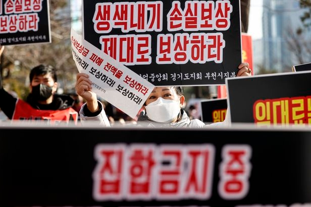 지난 8일 서울 영등포구 여의도 국회 인근에서 열린 ‘코로나 피해 실질 보상 촉구 정부 여당 규탄대회’에서 코로나피해자영업총연합(코자총) 회원들이 실질적인 손실보상 및 집합제한 명령 전면 해제 등을 촉구하는 내용의 손 피켓을 들고 있다. [연합]