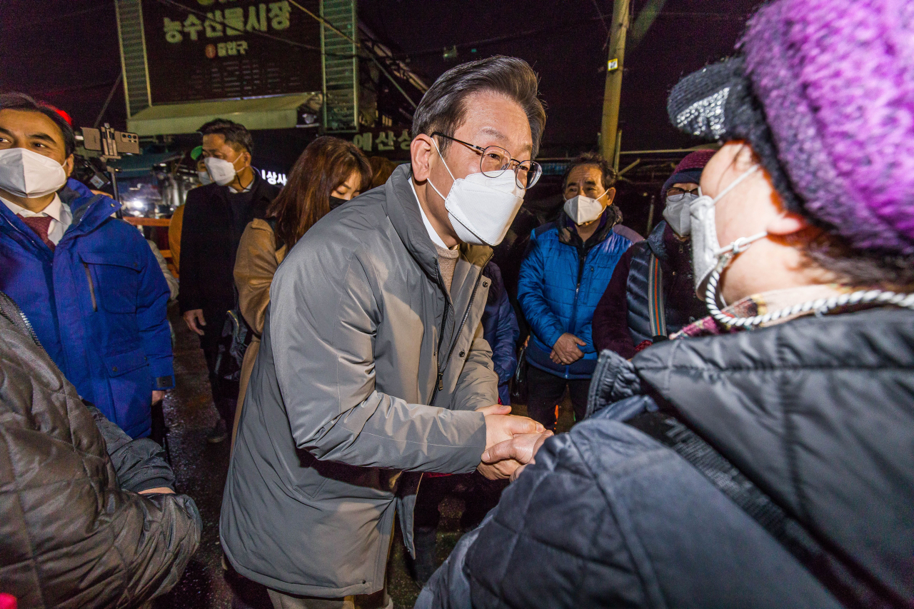 더불어민주당 이재명 대선후보가 지난 20일 서울 동대문구 청량리 농수산물시장 화재현장을 찾아 피해 상인을 위로하고 있다. [연합]