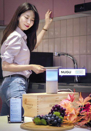 SK텔레콤 홍보 모델이 누구 캔들에서 알렉사(Alexa)가 탑재된 누구 멀티 에이전트 서비스를 시연하고 있다. [SK텔레콤 제공]