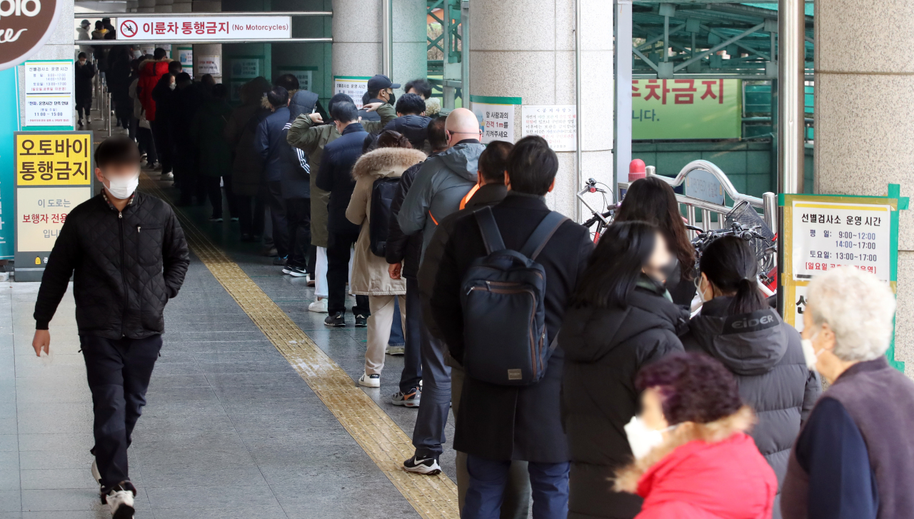 People line up at a makeshift clinic in central Seoul on Tuesday to get tested for COVID-19. (Yonhap)