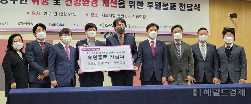 김도식 서울시 정무부시장이 구자권 쌍방울그룹 부회장으로부터 노숙인과 쪽방촌 주민 등에게 지원할 10억원 상당의 겨울 내의 2만점을 기부받고 있다.