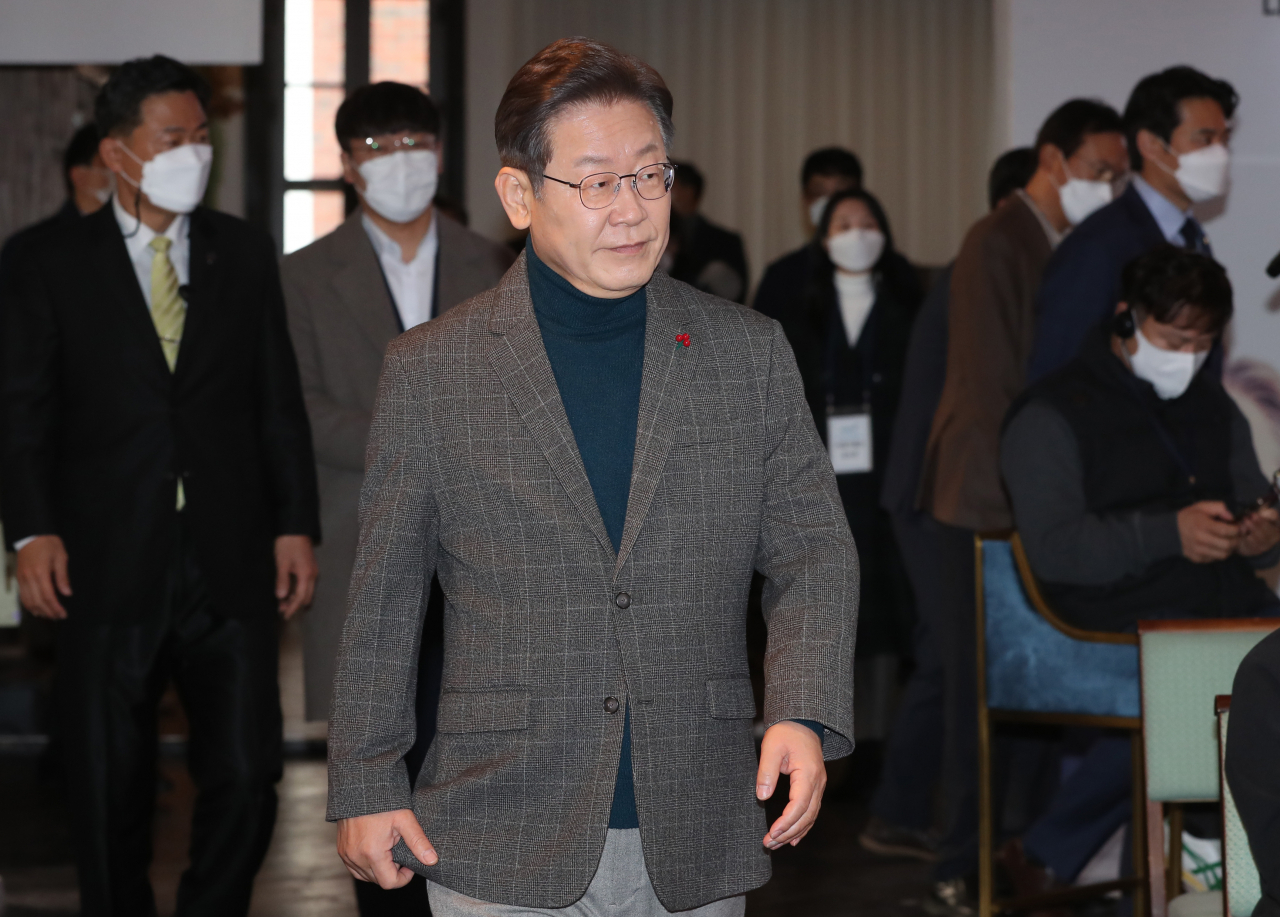 더불어민주당 이재명 대선후보가 21일 서울 중구 정동1928 아트센터 이벤트홀에서 마이클 샌델 하버드대 교수와 '대전환의 시대, 대한민국은 어떻게 공정의 날개로 비상할 것인가'의 주제로 화상 대담을 하기 위해 대담장으로 들어오고 있다. 이번 대담에는 온라인을 통해 공개 모집한 국민참여단 현장 패널 15명도 참석했다. [연합]