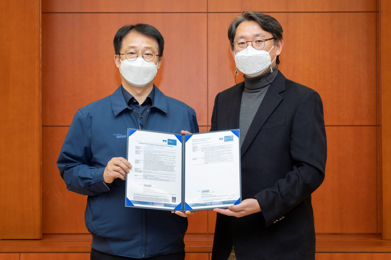 지난 21일 현대로템 의왕 본사에서 김종년 현대로템 레일솔루션연구소장(왼쪽)과 신석균 리카르도 레일 동아시아 대표가 진접선 전동차 독립안전성평가 인증서를 들고 기념촬영을 하고 있다. [현대로템 제공]