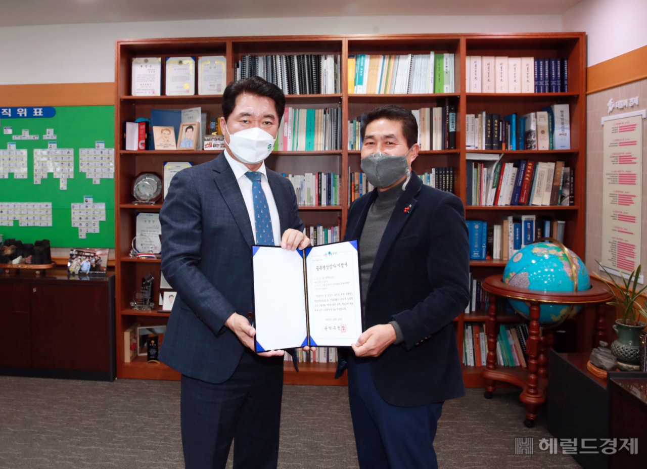 박준희(왼쪽) 관악구청장이 고경연 난곡 골목형상점가 회장에게 난곡 골목형상점가 지정서를 전달하고 기념사진을 찍고 있다.[관악구]
