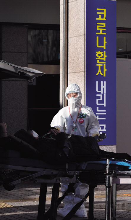 코로나19 위중증 환자가 1000명을 넘은 21일 오전 서울 은평구 서울시립서북병원에서 머리부터 발끝까지 방호복으로 몸을 감싼 간호사가 퇴원하는 환자를 구급차로 옮기고 있다. 중앙방역대책본부에 따르면 이날 0시 기준 위중증 환자수는 1063명으로 집계됐고, 신규확진자 수는 7456명을 기록해 다시 7000명대를 넘어섰다. 박해묵 기자