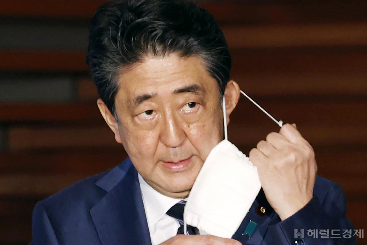 2020년 5월 21일에 일명 아베노마스크를 벗고 있는 아베 신조 전 일본 총리 [AP]