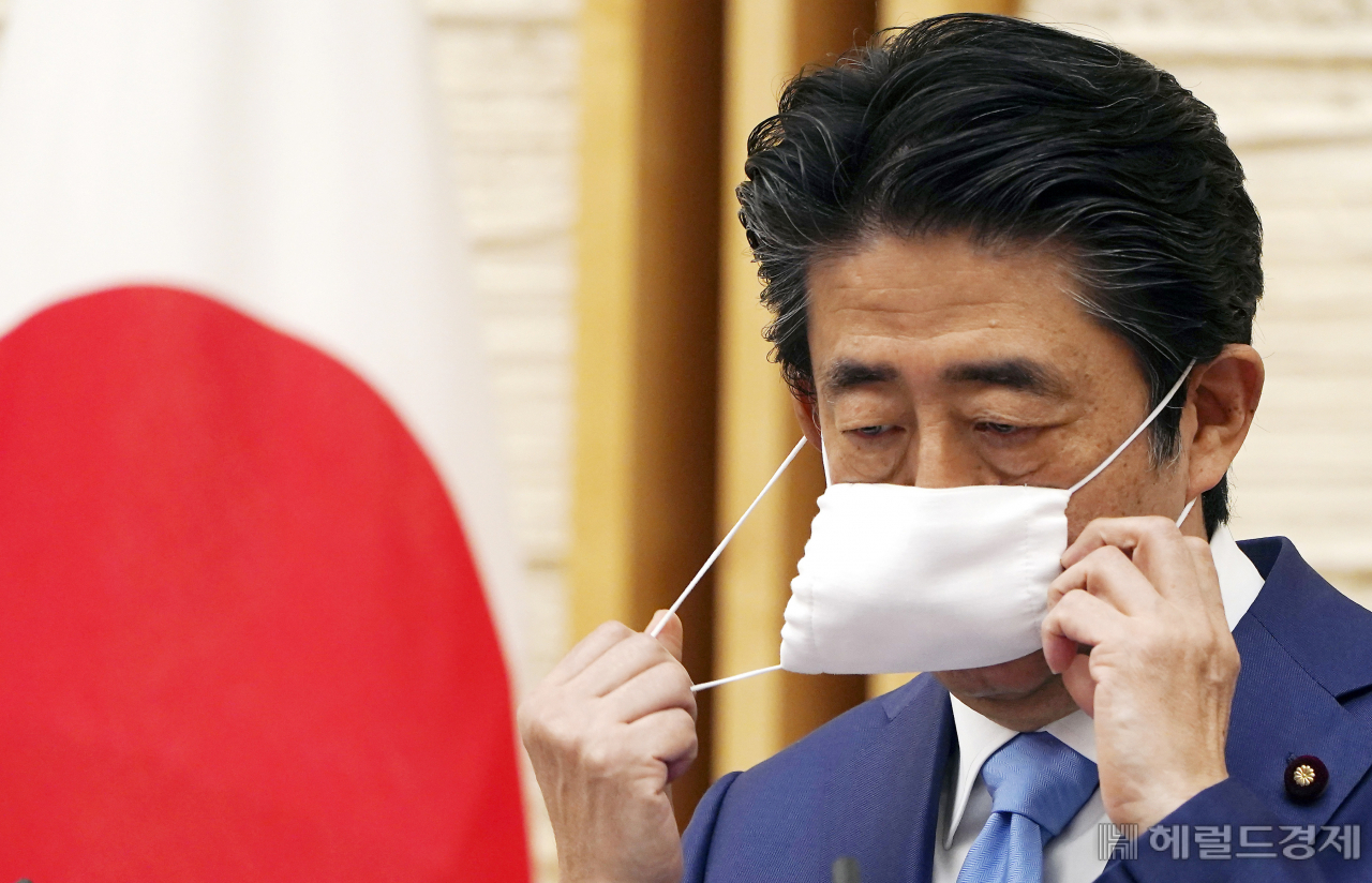 2020년 5월 4일에 일명 아베노마스크를 벗고 있는 아베 신조 전 일본 총리 [AP]