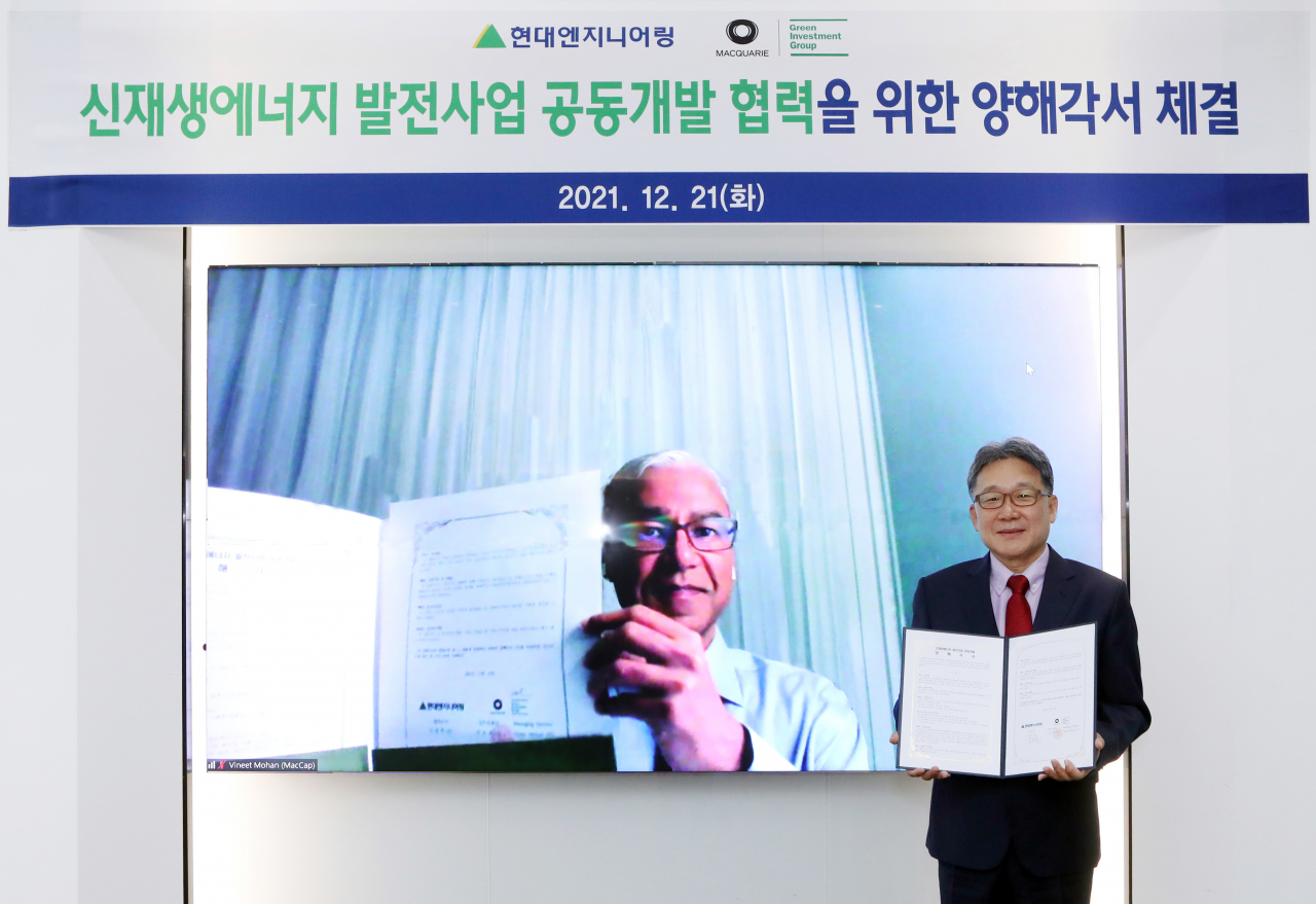 현대엔지니어링 김창학 대표이사(오른쪽)와 맥쿼리 그린인베스트먼트그룹 비닛 모한 EPC총괄대표가 지난 21일 비대면 MOU(양해각서) 체결식을 갖고 기념촬영을 하고 있다. [현대엔지니어링 제공]