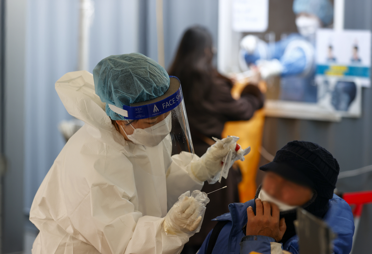 23일 오전 서울역 광장에 마련된 코로나19 임시선별검사소에서 시민이 검사를 받고 있다. [연합]